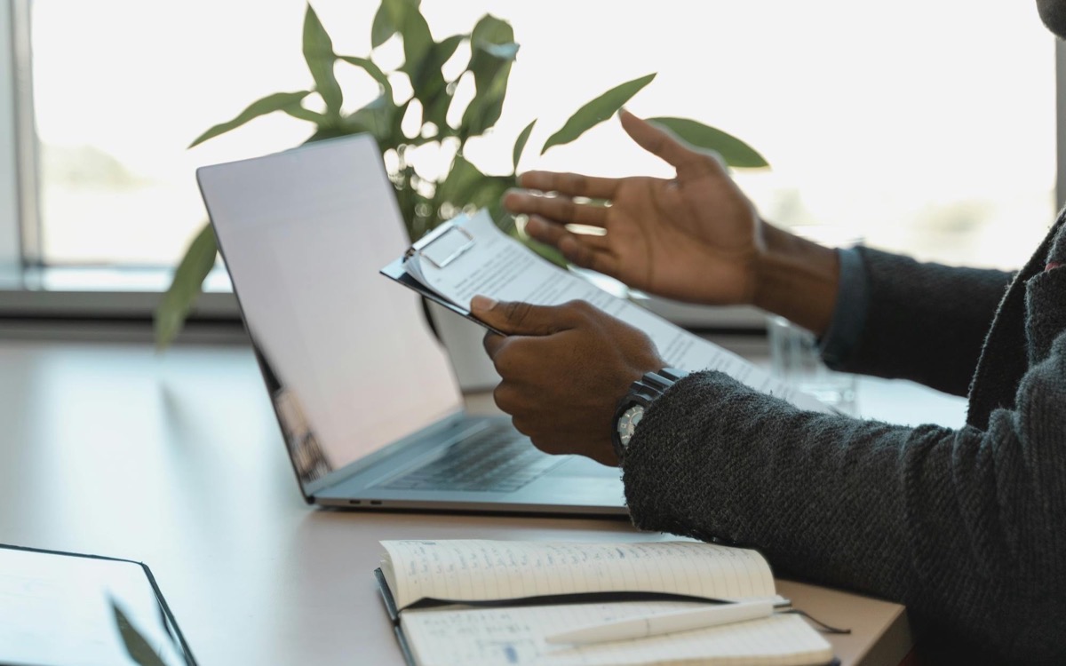 A consultant reviewing documents beside a laptop and notebook